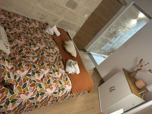 une chambre avec un lit avec un couvre-lit fleuri dans l'établissement Le Nid de St-Marc, à Villeneuve-lès-Avignon