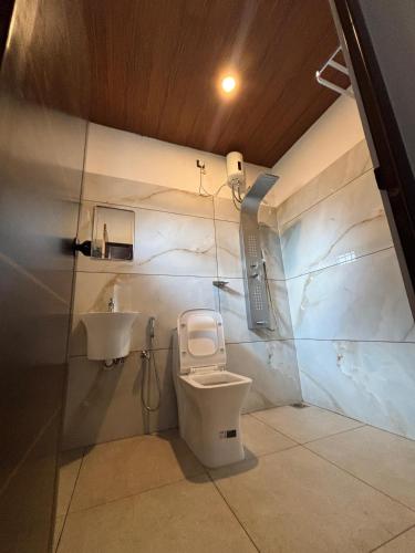 a bathroom with a toilet and a sink at BirdScapes Kumarakom Homestay in Kumarakom