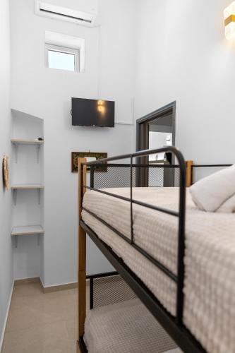 a bedroom with two bunk beds and a tv at VaSteka House 2 in Haraki