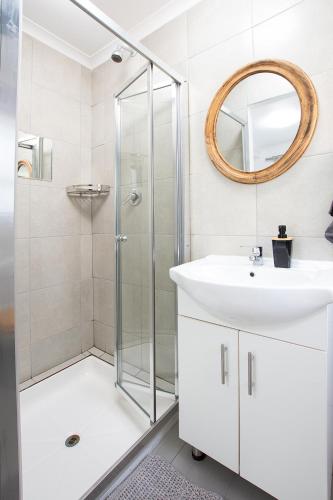 a white bathroom with a shower and a sink at Bo Kant - Hooggety in George