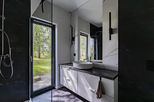 a bathroom with a sink and a mirror at Glow Apartments - Dom Ostoja Rekownica, Kaszuby na 10 osób z sauną i balią in Będomin