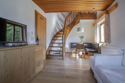 a living room with a staircase and a couch and a table at Landhaus Schneider in Schruns-Tschagguns