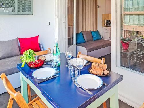 une table bleue avec des assiettes et des verres à vin dans l'établissement Apartment Diamant bleu by Interhome, à Six-Fours-les-Plages