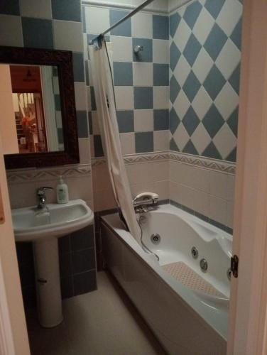 a bathroom with a bath tub and a sink at Casa Rural Hidalgo II in Alcolea de Calatrava