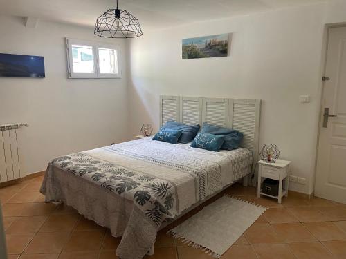 une chambre avec un lit avec des oreillers bleus dessus dans l'établissement villa Dolce Vita en Provence, à Ceyreste