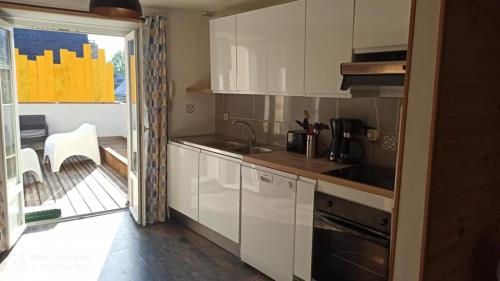 a kitchen with white cabinets and a stove top oven at Taol-Kalon -coup de coeur- in Tréguier