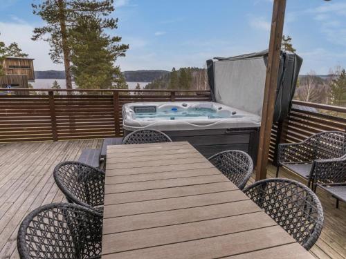 einen Whirlpool auf einer Terrasse mit einem Tisch und Stühlen in der Unterkunft Holiday Home Villa kaarina by Interhome in Lohja