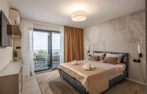 a bedroom with a large bed and a balcony at Villa Aris by Villas Guide in Urinj