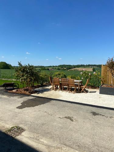two benches and a picnic table in a park at Gite 8-10 pers, 4 chambres, billard, jardin in La Bouexière
