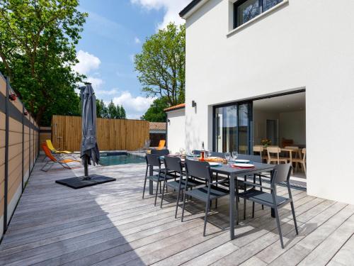 a patio with a table and chairs on a deck at Holiday Home Le Pré Tarin by Interhome in La Bernerie-en-Retz