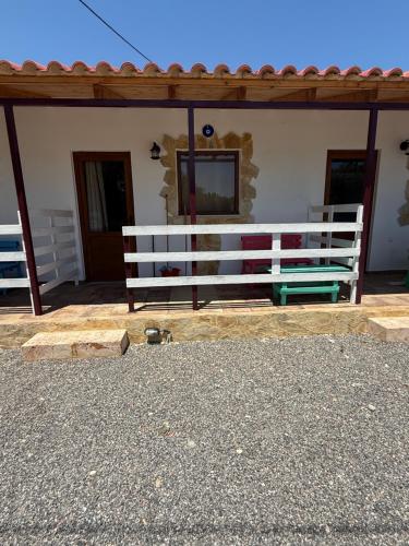 two white benches sitting in front of a building at Dimitris room kamares 2 in Kamáres