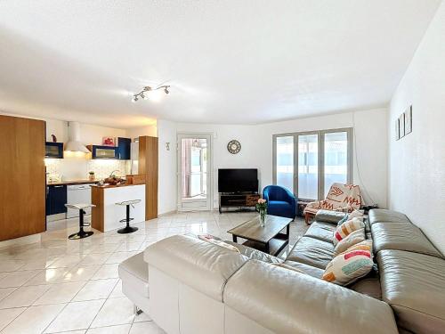 un salon avec un canapé et une cuisine dans l'établissement Holiday Home Maison Valoma by Interhome, à Lunel