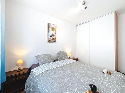 a bedroom with a bed and two lamps in it at Holiday Home Maison Valoma by Interhome in Lunel