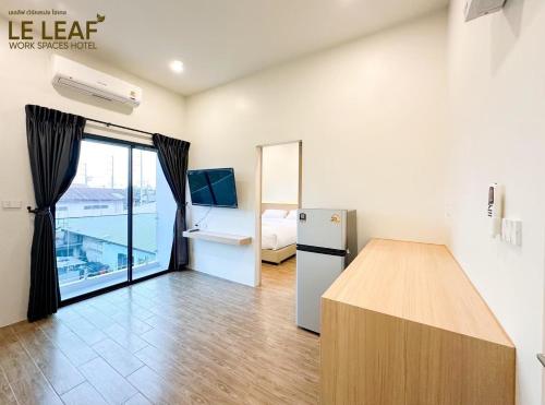 una camera con frigorifero e una camera con letto di Leleaf Work Spaces Hotel - เลอลีฟ เวิร์คสเปซ โฮเทล a Sakon Nakhon