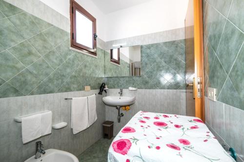 a small bathroom with a bed and a sink at CasaVacanzeAurora in San Vito lo Capo