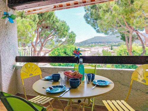 - une table avec des assiettes et une bouteille de vin sur le balcon dans l'établissement Apartment L'Ile heureuse-9 by Interhome, à Saint-Cyr-sur-Mer