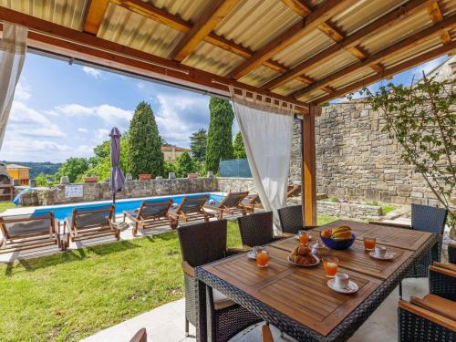a patio with a table and chairs and a pool at Holiday Home Villa Letizia by Interhome in Oprtalj