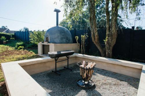a barbecue grill in a backyard with a fence at 17 Dicks Street Clubhouse in Howick