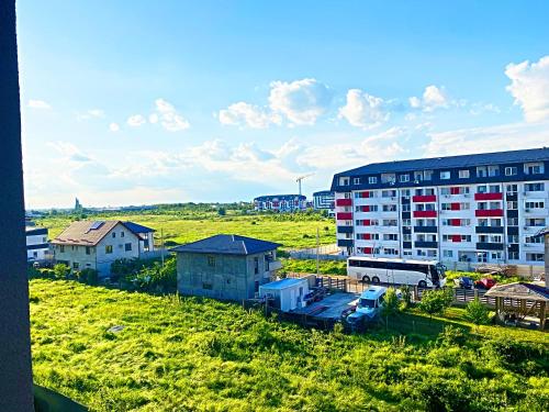 a large apartment building in a field next to a building at Studio Full Kitchen AC Free Parking Popcorn Wine in Chiajna