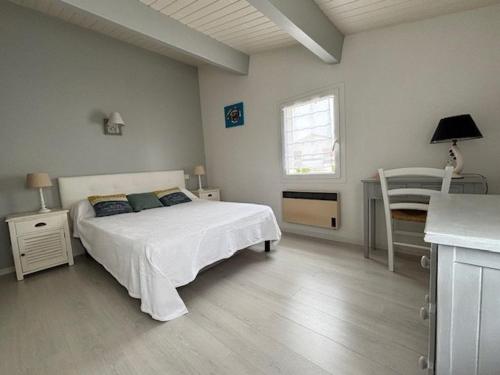 une chambre avec un lit, une table et une fenêtre dans l'établissement Appartement rénové à Royan, proche plage, terrasse, parking privé - FR-1-494-102, à Royan