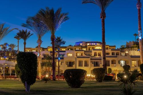 a large building with palm trees in front of it at Grand Oasis Resort in Sharm El Sheikh