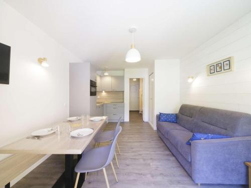 un salon avec un canapé bleu et une table dans l'établissement Studio rénové à Gourette, 4 pers, animaux admis, wifi - FR-1-400-140, à Eaux-Bonnes