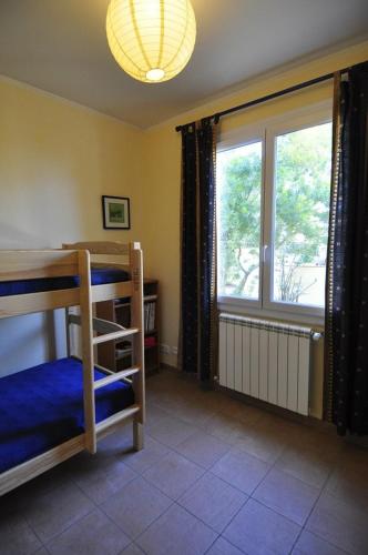 - une chambre avec des lits superposés et une grande fenêtre dans l'établissement Villa, 3 chambres, vue mer, wifi, jardin, tout confort, à La Seyne-sur-Mer