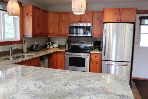 a kitchen with wooden cabinets and stainless steel appliances at Cedar House Restaurant & Chalets in Golden