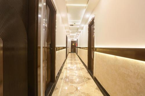 a hallway with a long corridor with doors and a tile floor at FabExpress Sugar Inn Near Rajouri Garden in New Delhi