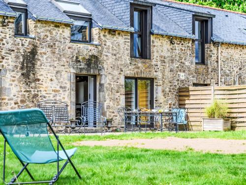a green chair in front of a stone house at Holiday Home Karvez by Interhome in Ploeren