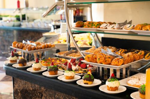 a buffet line with desserts and pastries on plates at Grand Oasis Resort in Sharm El Sheikh