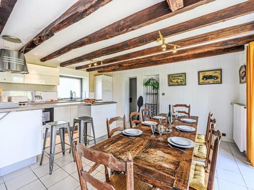 a kitchen and dining room with a wooden table and chairs at Holiday Home Karvez by Interhome in Ploeren