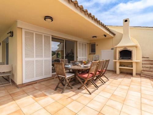 un patio avec une table, des chaises et une cheminée dans l'établissement Holiday Home Villa Marina by Interhome, à Porto-Vecchio