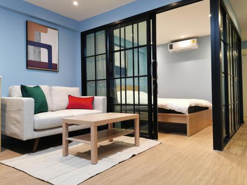 een woonkamer met een bank en een tafel bij BEB Silom Condolette in Bangkok