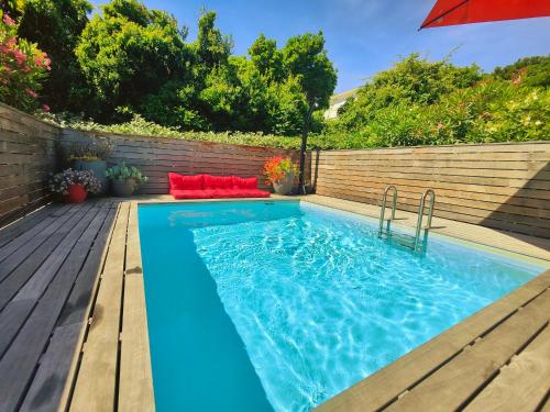 a swimming pool with an umbrella on a wooden deck at Villa avec piscine privée à Sisco in Sisco