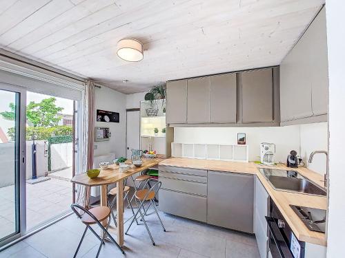 une cuisine avec une table et quelques chaises dans l'établissement Holiday Home Les Marines-5 by Interhome, au Barcarès