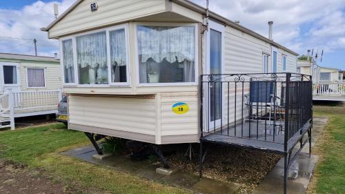a chicken house with a gate in front of a house at Beachside, Family-friendly, WiFi, 6 berth Caravan 19 in Ingoldmells in Ingoldmells