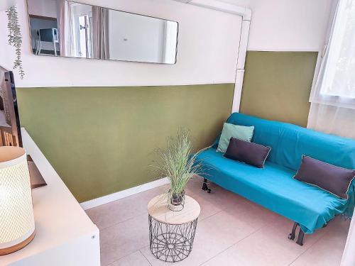 un salon avec un canapé bleu et une table dans l'établissement Holiday Home Les Marines-5 by Interhome, au Barcarès