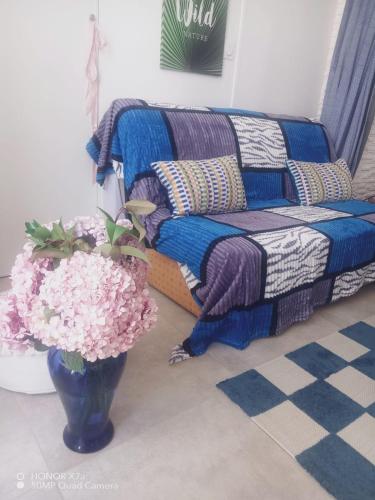 - un salon avec un canapé et un vase fleuri dans l'établissement chambre chez l'habitant, à Fréjus