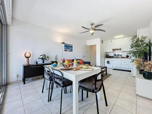 - une cuisine avec une table et des chaises blanches dans la chambre dans l'établissement Apartment Le Galaxie by Interhome, au Grau-du-Roi