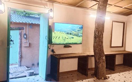 a room with a table and a tree in it at Rural Sense Organic Farm Stay in Faridabad