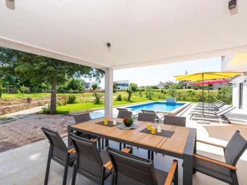 a patio with a table and chairs and a swimming pool at Holiday Home Vala by Interhome in Vodnjan