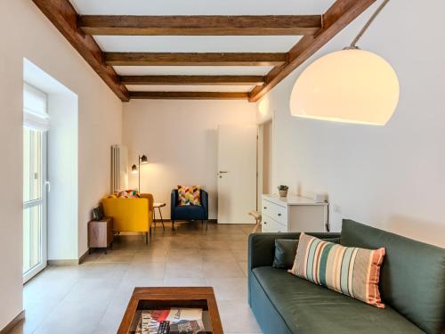 a living room with a green couch and a table at Apartment Tre Laghi by Interhome in Carlazzo