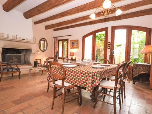 une salle à manger avec une table et des chaises et une cheminée dans l'établissement Holiday Home Le Jardin by Interhome, à Bernis