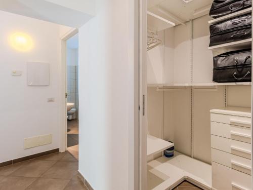 a walk in closet with white cabinets and a mirror at Apartment Tre Laghi by Interhome in Carlazzo