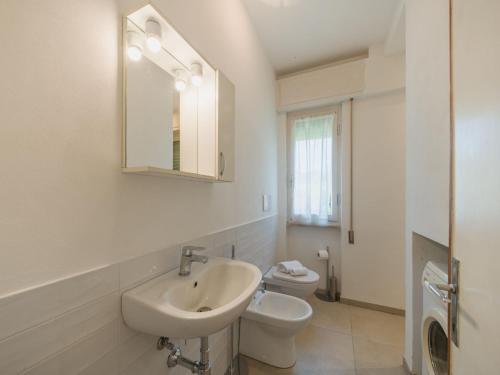a white bathroom with a sink and a toilet at Apartment appartamento Stipeto by Interhome in Marina di Pietrasanta