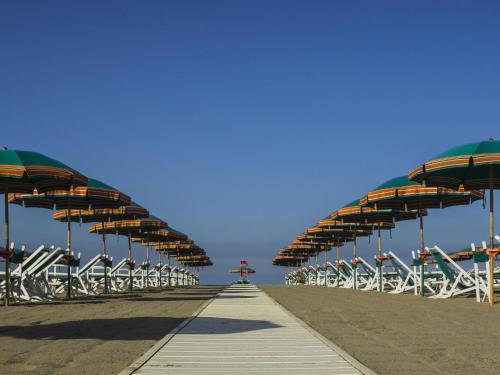 a boardwalk with chairs and umbrellas on the beach at Apartment appartamento Stipeto by Interhome in Marina di Pietrasanta
