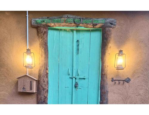 a blue door in the side of a building with two lights at Rural Sense Organic Farm Stay in Faridabad