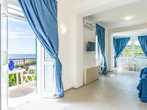una sala de estar con cortinas azules y vistas al océano. en Apartment Nausicaa by Interhome, en Arma di Taggia