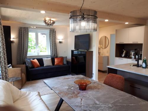 a kitchen and living room with a table and a couch at Schafberg Luxury Apartment in St. Wolfgang